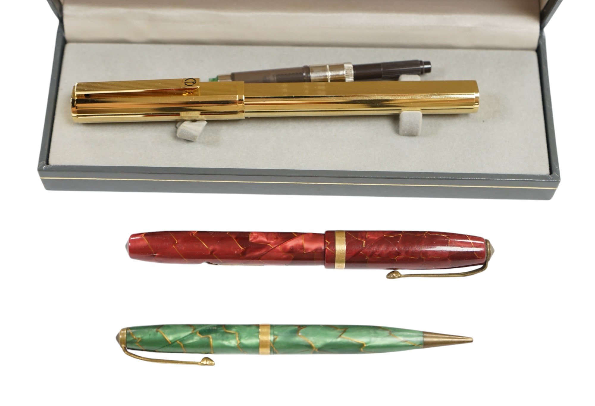 A cased Dunhill gold plated fountain pen and two other pens, Dunhill pen 13.5cm long. Condition - fair